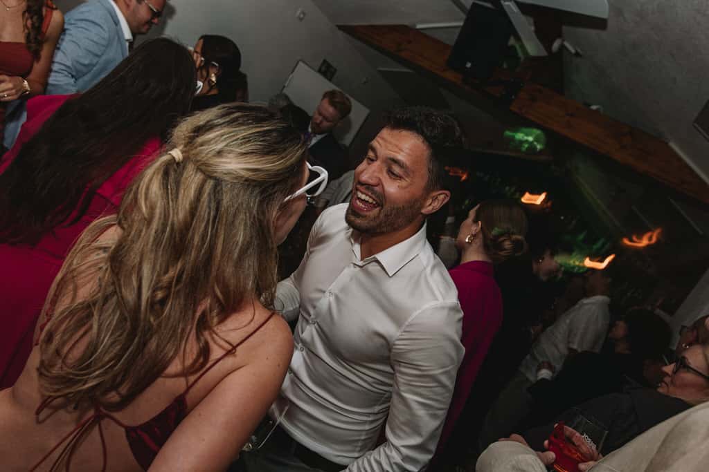 Ein Mann und eine Frau in einem Raum mit einer Menschenmenge Tanzen