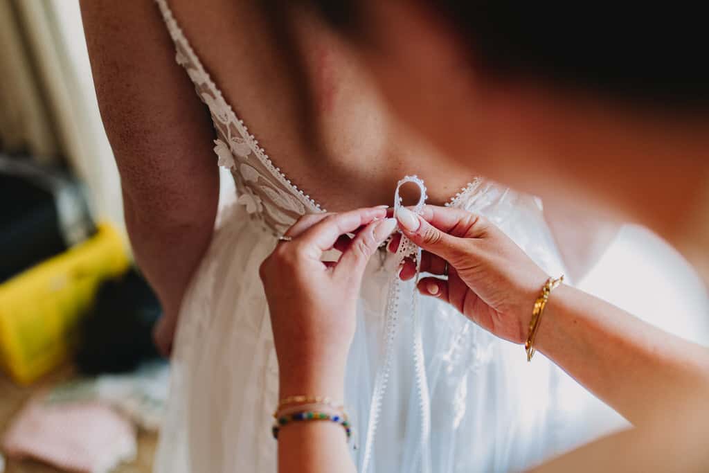 Eine Person, die ein Spitzenkleid bindet