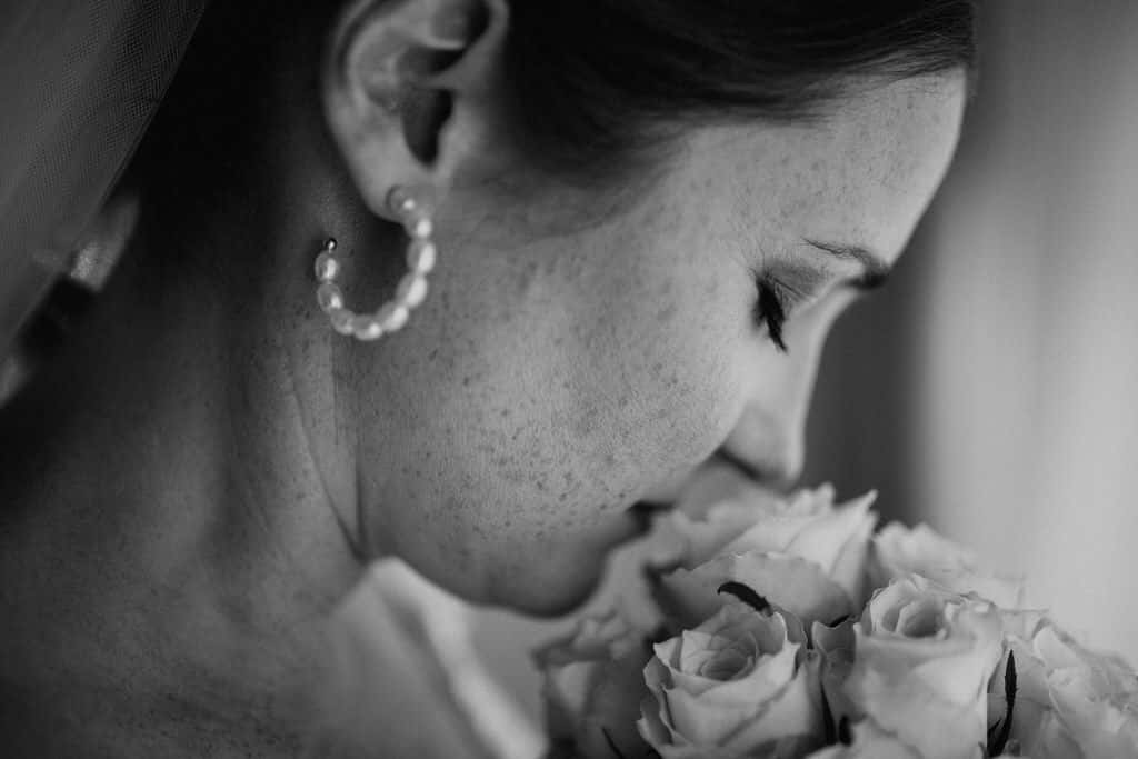 Eine Frau riecht an einem Rosenstrauß