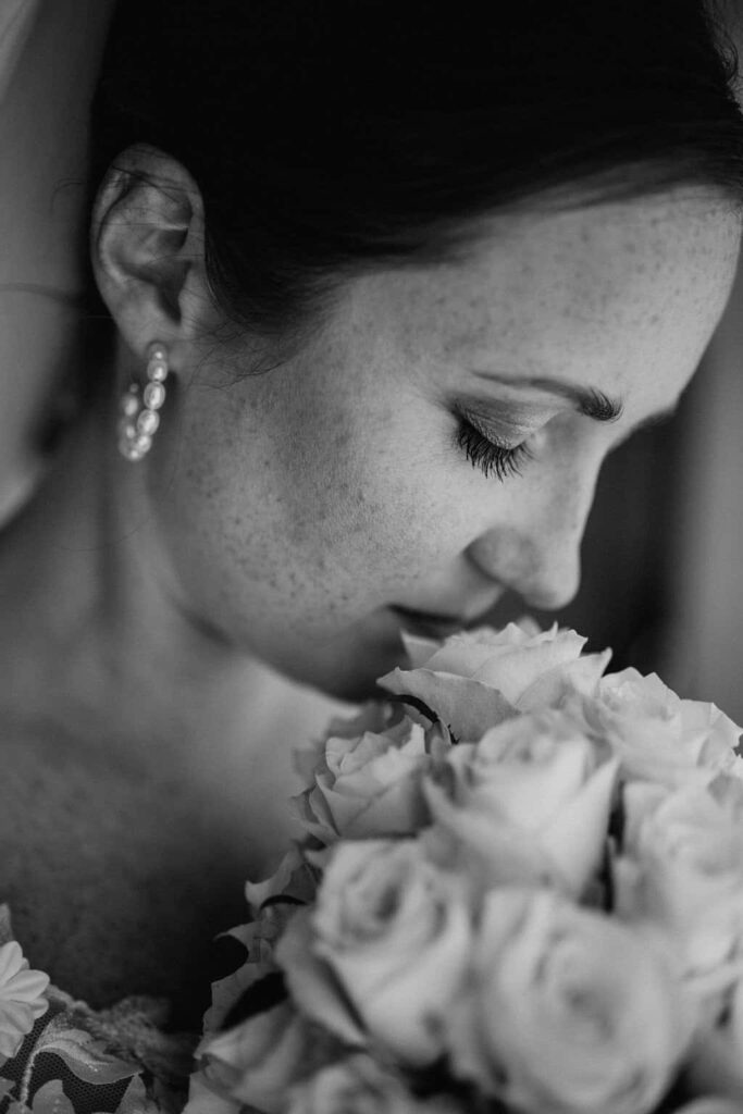 Eine Frau riecht an einem Rosenstrauß