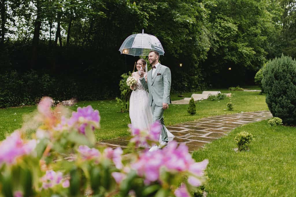 Ein Mann und seine Frau haben einen Regenschirm und gehen spazieren im Regen.