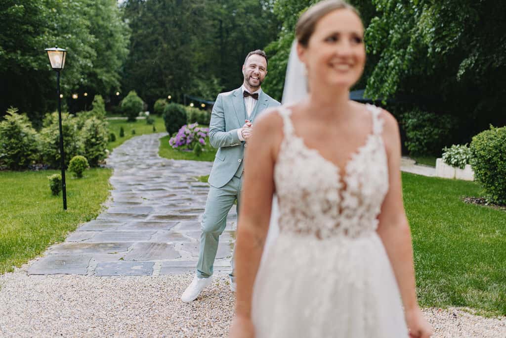 Ein Mann steht hinter seiner Frau und Lacht sie an