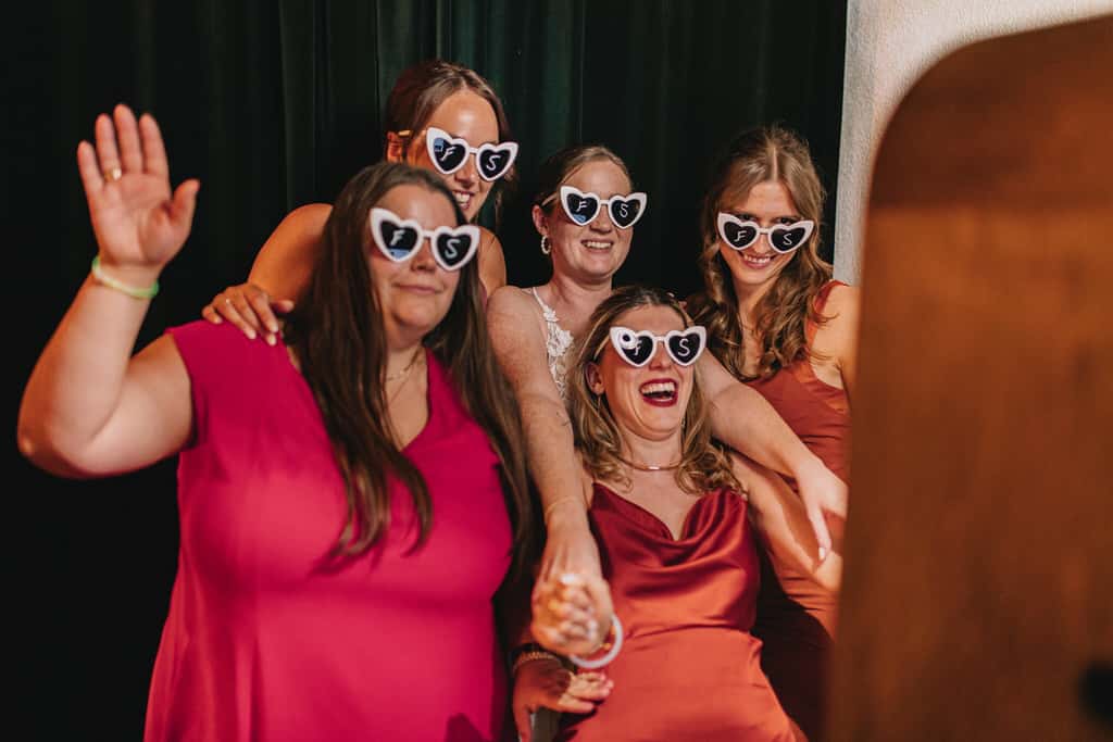 Eine Gruppe von Frauen mit weißen herzförmigen Sonnenbrillen